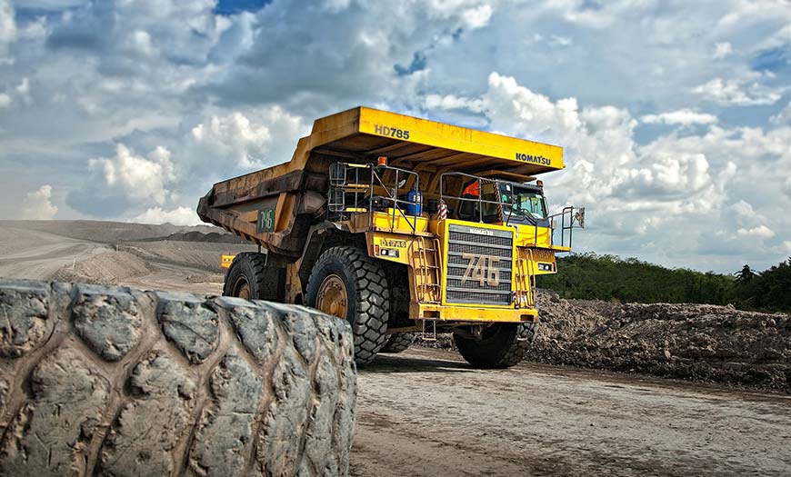 Man Using Measuring Tape in Factory Setting Man Using Measuring Tape in Factory Setting